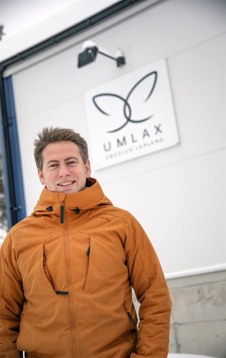 Bild på Emanuel Nygren, vd för Umlax, som står utanför företagsbyggnaden med skylt där det står "Umlax".